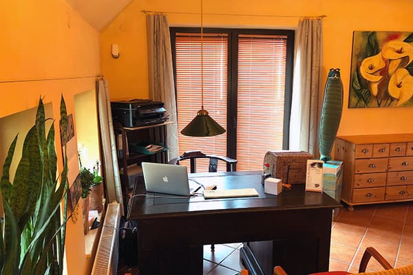 Behandlungszimmer mit Schreibtisch und warmem Ambiente